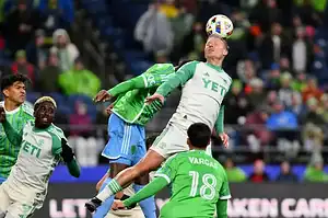 Austin FC player leaps to head the ball during a match against St. Louis City SC.
