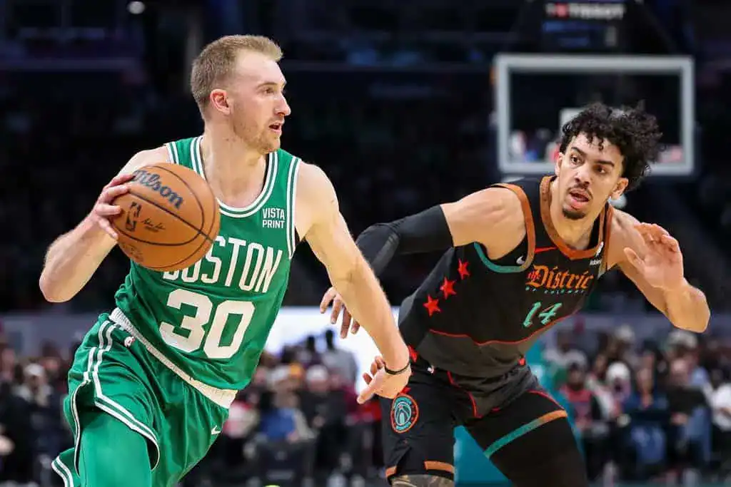 Boston Celtics player driving forward with the ball while being guarded by a Washington Wizards player in an NBA matchup.