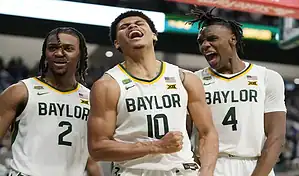 Baylor Bears basketball players celebrate together on the court after a big play during an NCAA game.