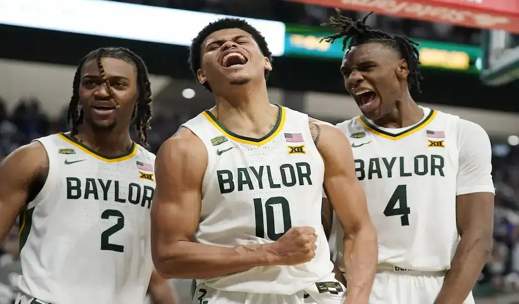 NCAAB 3 Baylor Bears basketball players celebrate together on the court after a big play during an NCAA game.