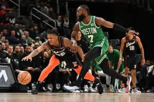 A Boston player hustles toward a loose ball during a fast-paced NBA game.