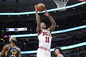 A Chicago Bulls player rises for a two-handed dunk while Indiana Pacers defenders look on during an NBA game.
