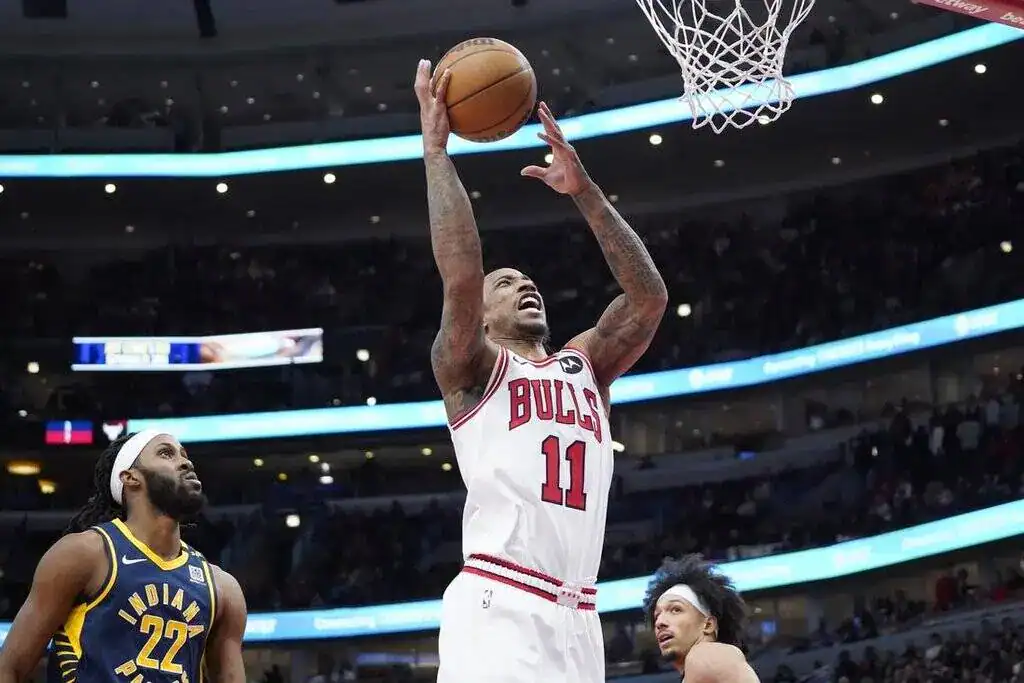 A Chicago Bulls player rises for a two-handed dunk while Indiana Pacers defenders look on during an NBA game.