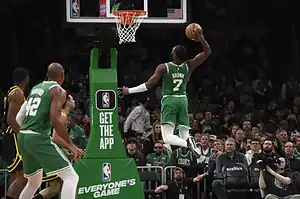 Boston Celtics player Jaylen Brown soars toward the basket for a powerful dunk during an NBA