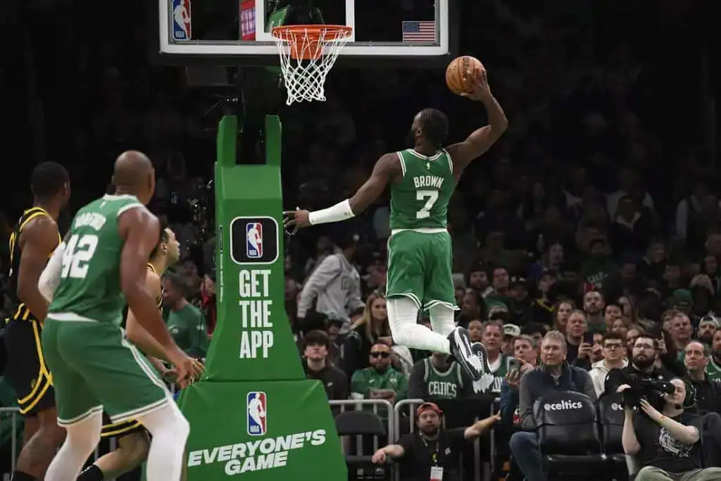Boston Celtics player Jaylen Brown soars toward the basket for a powerful dunk during an NBA