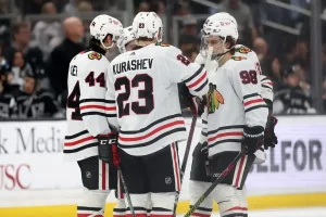 Chicago Blackhawks players huddle on the ice during a break in play.