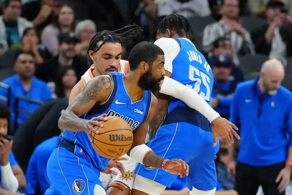 Dallas Mavericks player dribbles around a screen set by a teammate.