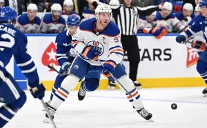 Edmonton Oilers captain, skates toward the puck during a game against the Toronto Maple Leafs.