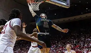 Morehead State player going up for a powerful dunk against Illinois defenders during a college basketball game.