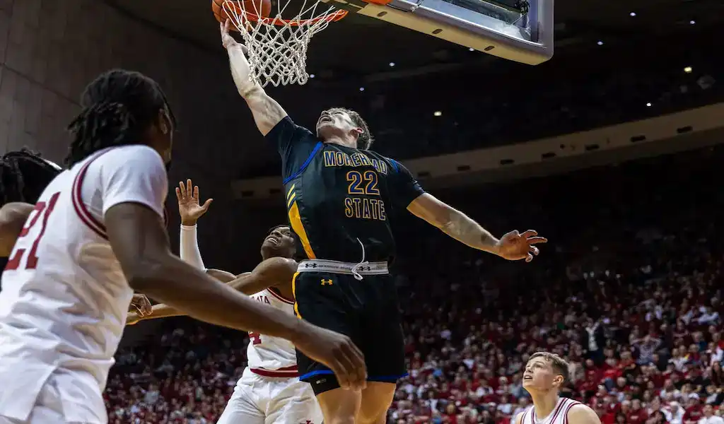 Morehead State player going up for a powerful dunk against Illinois defenders during a college basketball game.