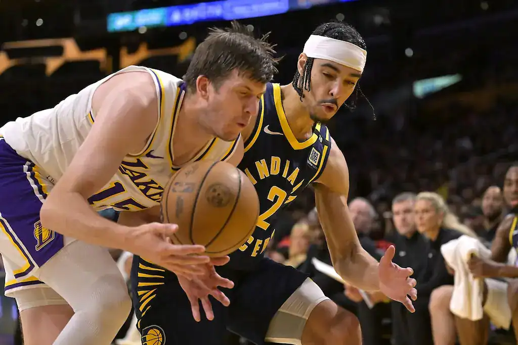 Los Angeles Lakers and Indiana Pacers players battle for a loose basketball during a game.