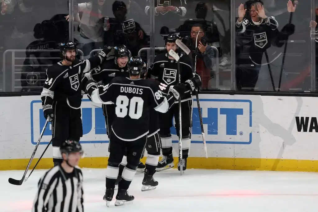 NHL 2 LA Kings hockey players celebrate near the glass.