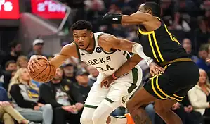 NBA game action with Milwaukee Bucks forward driving to the basket against Los Angeles Lakers defender on March 8, 2024.