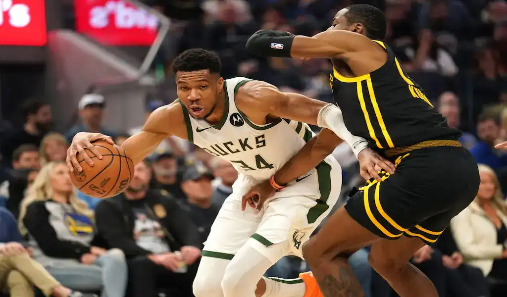 NBA game action with Milwaukee Bucks forward driving to the basket against Los Angeles Lakers defender on March 8, 2024.
