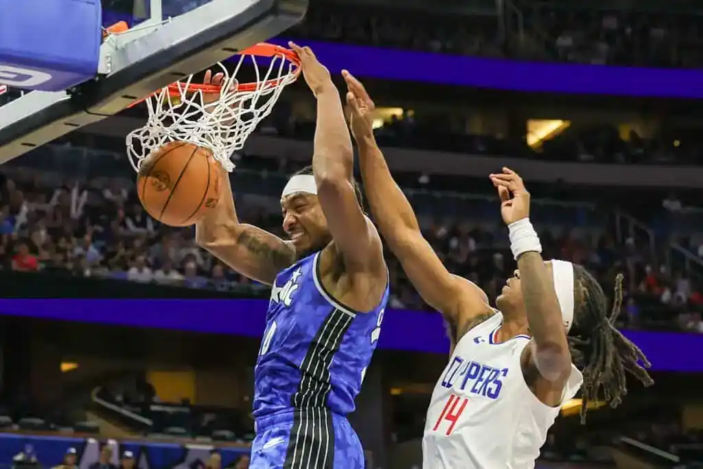 3 Orlando Magic player dunks against Clippers defender.