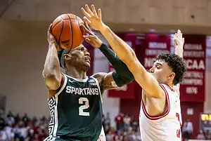 Michigan State Spartans basketball player going up for a shot against Indiana Hoosiers defender.