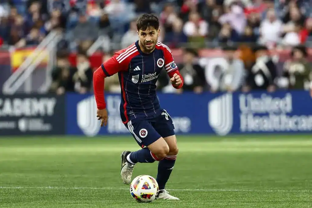 New England Revolution player dribbles the ball during an MLS match.