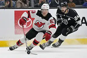 New Jersey Devils hockey player #63 skates past a Los Angeles Kings player.