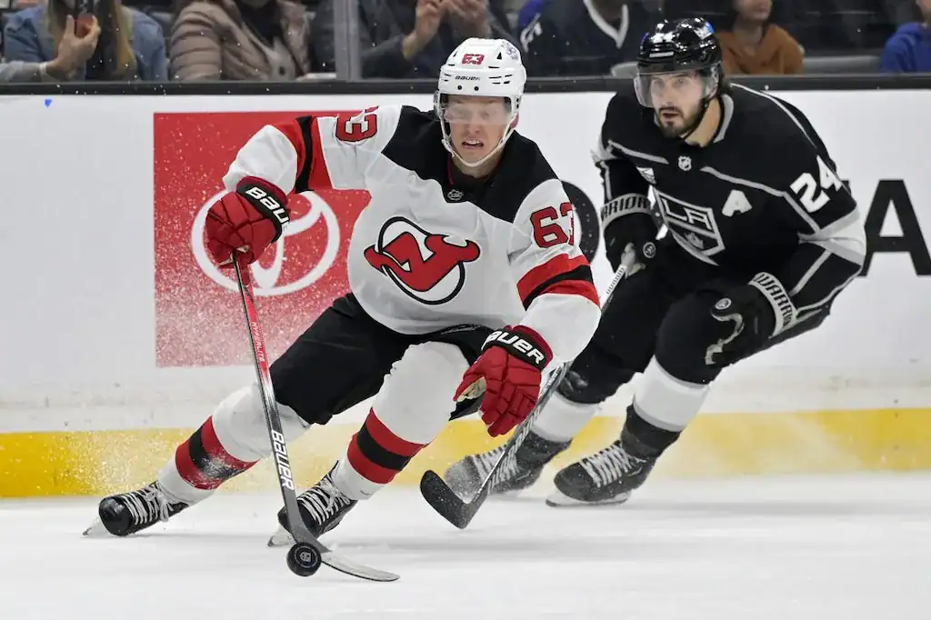 New Jersey Devils hockey player #63 skates past a Los Angeles Kings player.