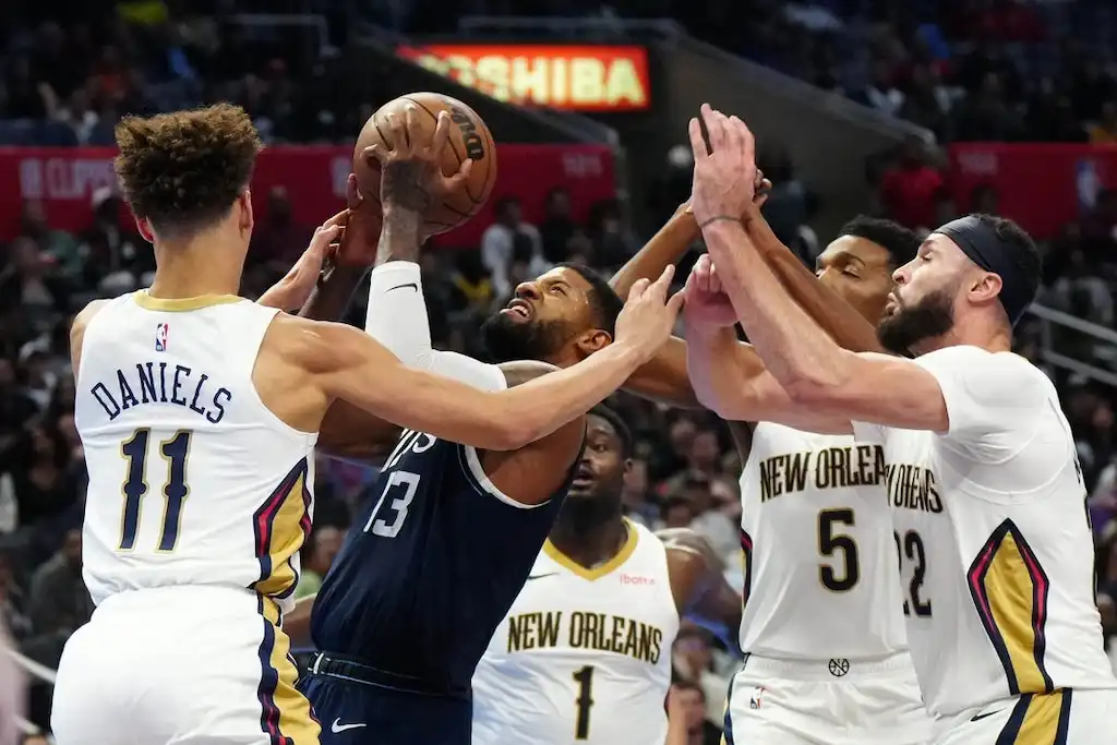 6 A basketball player attempts a contested shot while surrounded by multiple NO Pelicans defenders.
