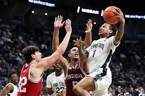 Penn State player drives to basket against Indiana defenders.