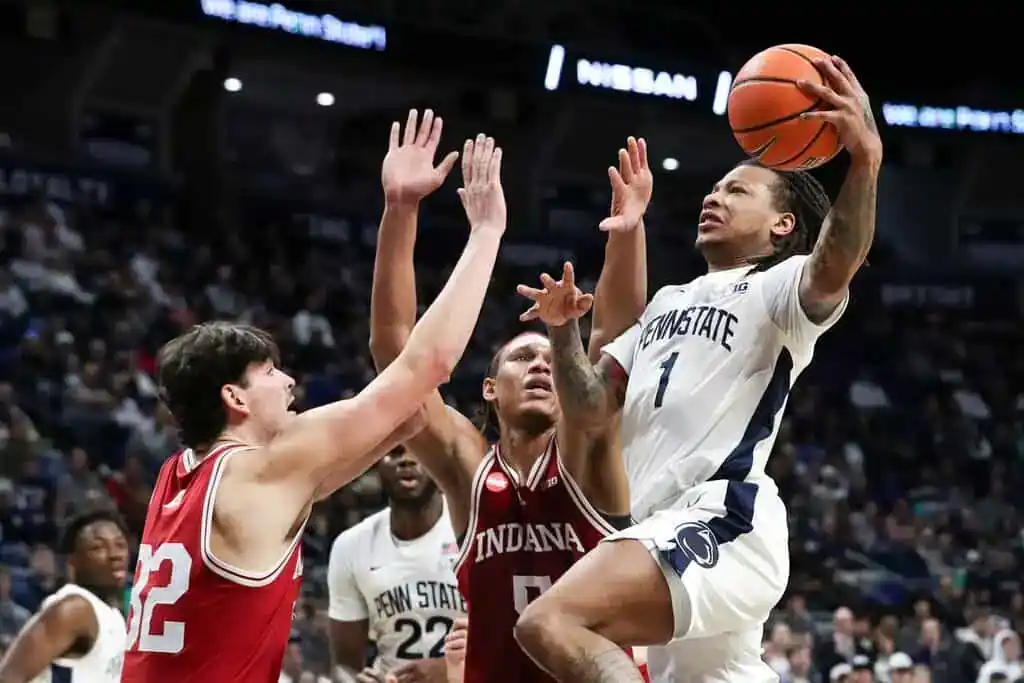 NCAAB 5 Penn State player drives to basket against Indiana defenders.