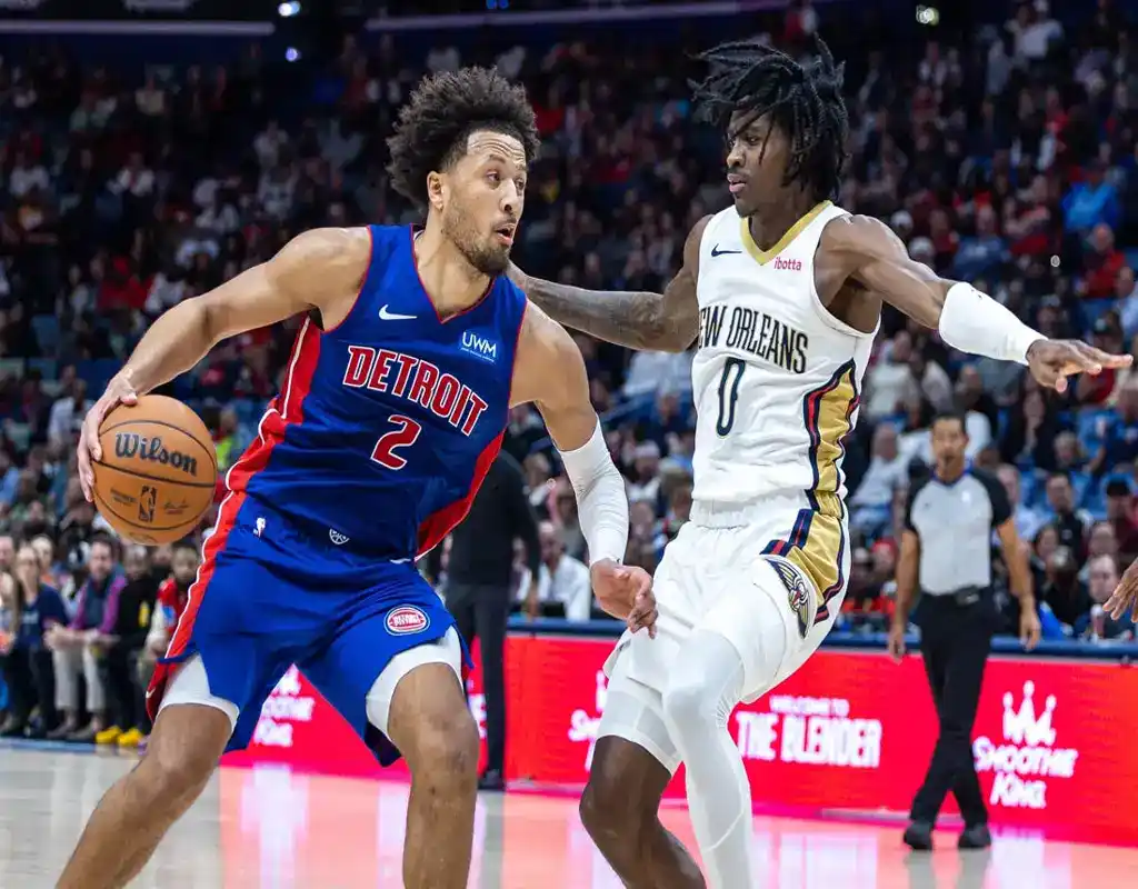 Detroit Pistons guard drives past New Orleans Pelicans defender during an NBA game