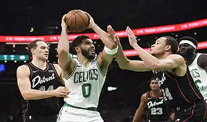 Boston Celtics player Jayson Tatum drives to the basket against Detroit Pistons defenders during a March 22, 2024, NBA game.