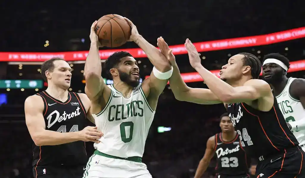 Boston Celtics player Jayson Tatum drives to the basket against Detroit Pistons defenders during a March 22, 2024, NBA game.