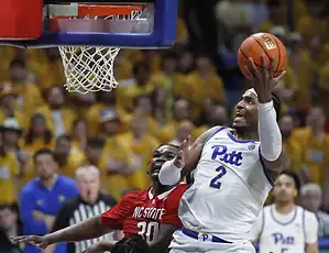 North Carolina player drives to the basket defended by an opposing player.
