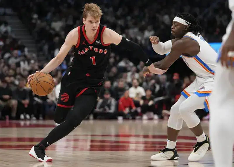 Toronto Raptors player in a black uniform dribbles the ball while being defended by an Oklahoma City Thunder player in a white jersey.