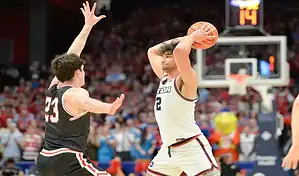 Dayton Flyers player holds the ball while defended by Saint Louis Billikens player during NCAA basketball game.