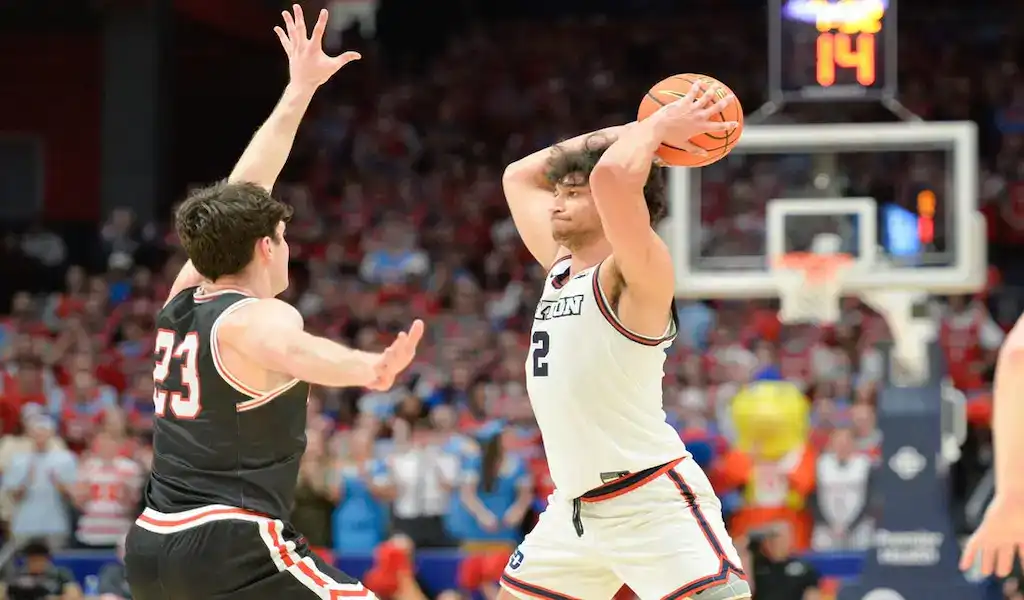 Dayton Flyers player holds the ball while defended by Saint Louis Billikens player during NCAA basketball game.