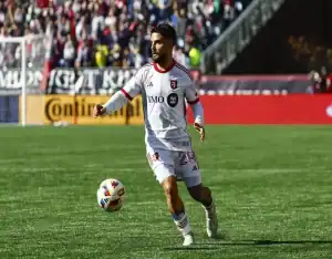 Toronto FC player controls the ball during match against Charlotte FC in front of a packed stadium