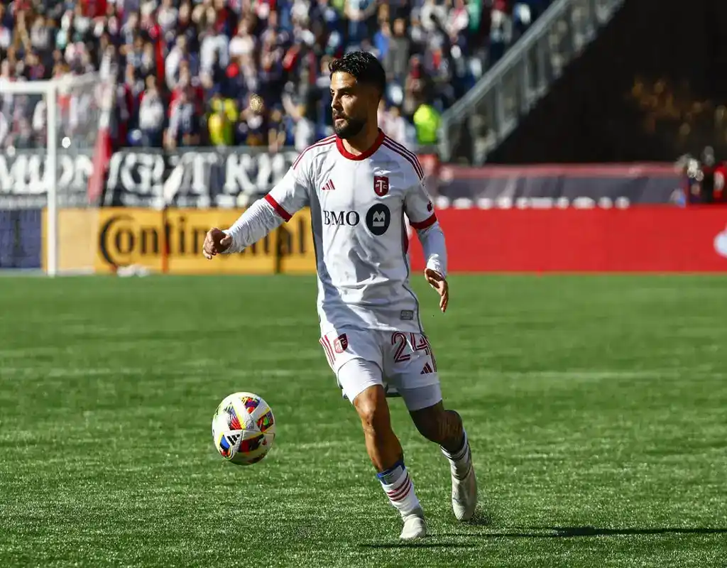 Toronto FC player controls the ball during match against Charlotte FC in front of a packed stadium