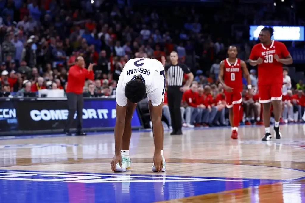 NCAAB 4 A University of Virginia Cavaliers player bends over in frustration at midcourt.