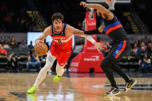 A Washington basketball player drives past a defender during a game.