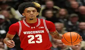 Wisconsin Badgers guard dribbles the ball against Maryland Terrapins during NCAA basketball game.