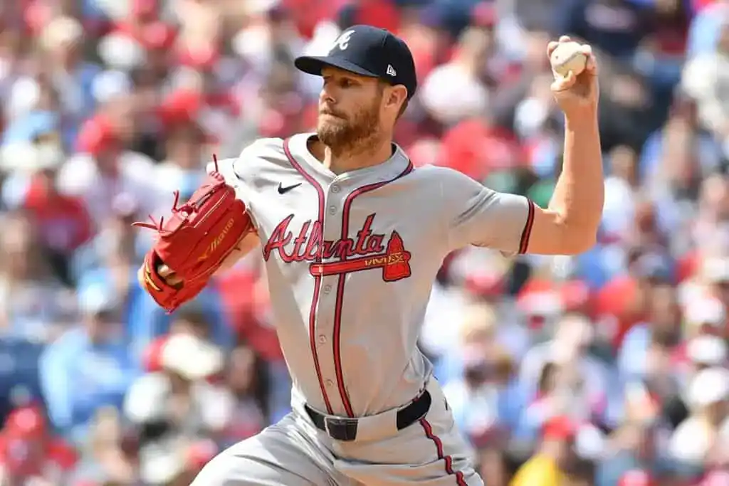3 Atlanta Braves pitcher winding up to throw during an MLB game, wearing a gray road uniform.