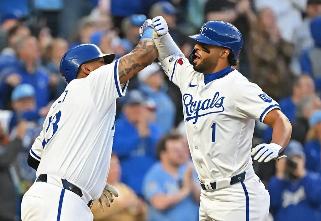 Two Kansas City Royals players celebrate with a high-energy forearm bump during a game.