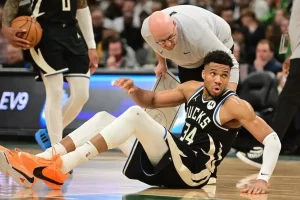 Giannis Antetokounmpo sits on the court after a play.