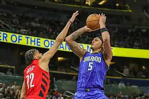 Orlando Magic player takes jump shot over Raptors defender.