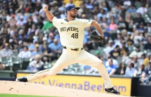 A Milwaukee Brewers pitcher winds up to throw a pitch.