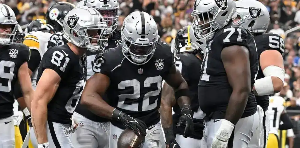 Las Vegas Raiders players huddle after big play.