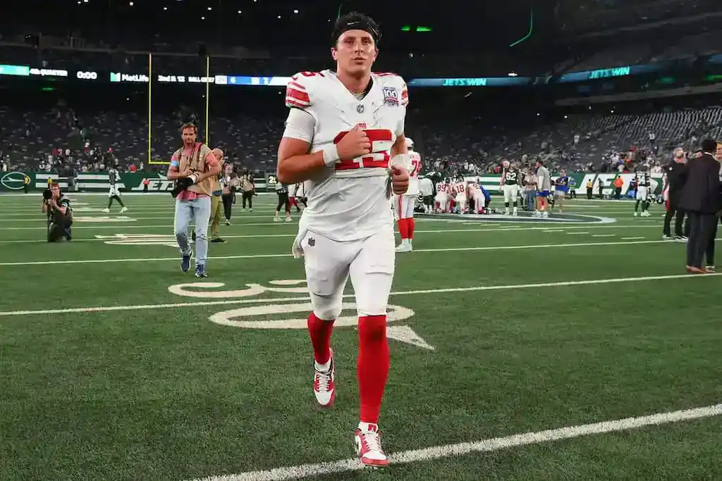 New York Giants football player jogs off the field after a game at MetLife Stadium.