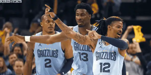 Phoenix-suns vs Memphis Grizzlies Picks and Predictions December 31st 2024 3 Memphis Grizzlies players Ja Morant (#12), Jaren Jackson Jr. (#13), and Xavier Tillman Sr. (#2) point and communicate on the court in light blue jerseys during an NBA game