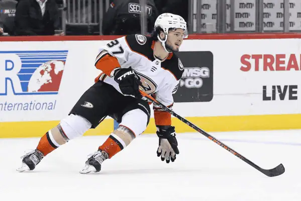 Calgary Flames vs Anaheim Ducks Picks and Predictions January 30th 2025 2 Anaheim Ducks hockey player wearing a white jersey and helmet, skating on the ice with the puck during a game.