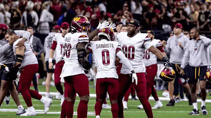  Washington Commanders players celebrate win on the field