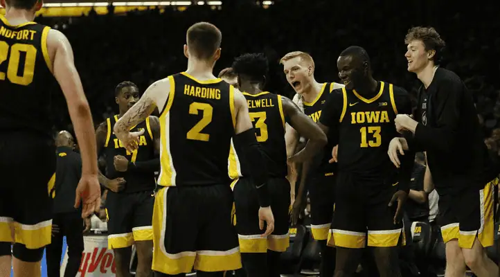 Usc Trojans vs Iowa Hawkeyes Picks and Predictions January 14th 2025 2 Iowa Hawkeyes players in black and yellow jerseys cheering and celebrating together during a college basketball game.