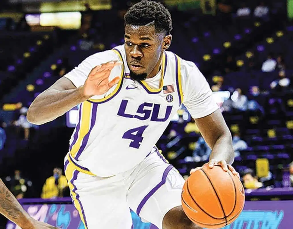 Lsu Tigers vs Arkansas Razorbacks Picks and Predictions January 14th 2025 2 A basketball player in an LSU uniform dribbles a ball, showcasing agility on the court against a vibrant crowd background.